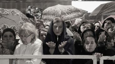 Creyentes durante una oración. La lluvia se hizo presente por algunos minutos. (Alan Monzón/Rosario3.com)