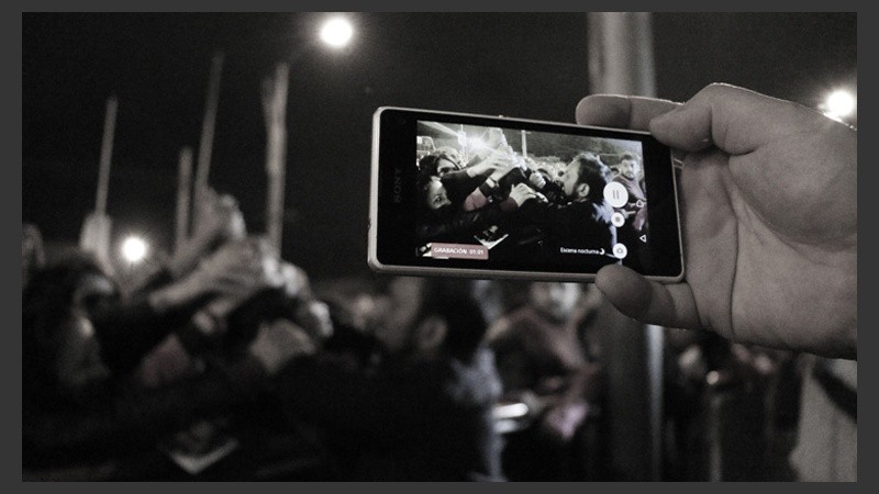 Un hombre registra con su celular el saludo del padre Ignacio con los fieles. (Alan Monzón/Rosario3.com)