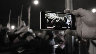 Un hombre registra con su celular el saludo del padre Ignacio con los fieles. (Alan Monzón/Rosario3.com)