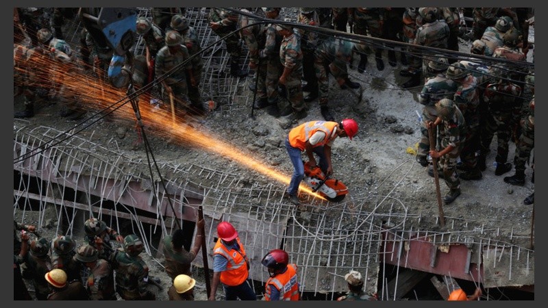 Miembros de la Fuerza de Respuesta de Desastres Nacionales (NDRF) trabajan para rescatar a las víctimas de un derrumbe. (EFE)