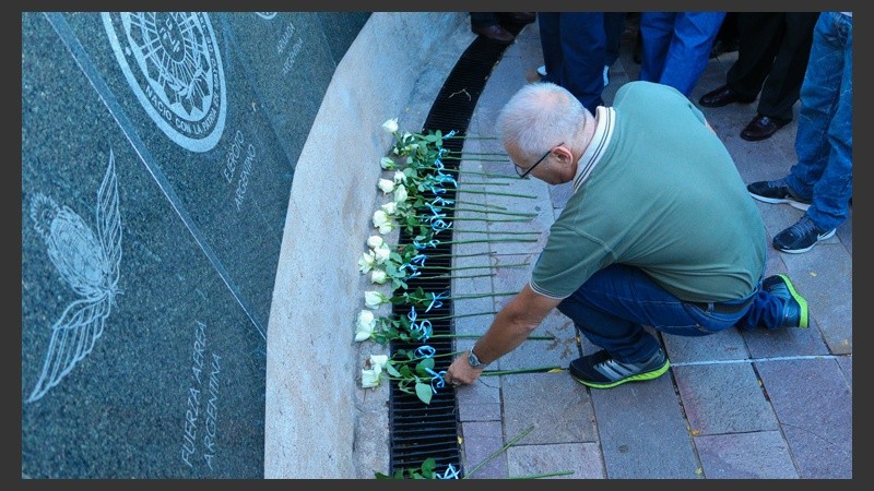 Un hombre deja una flor recordando a los que perdieron la vida en las islas. (Alan Monzón/Rosario3.com)