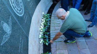 Un hombre deja una flor recordando a los que perdieron la vida en las islas. (Alan Monzón/Rosario3.com)