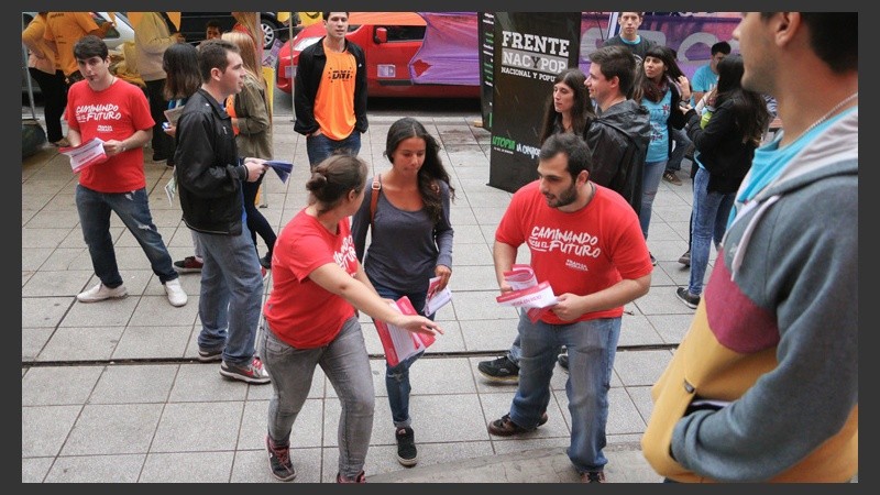 Una estudiante es rodeada por militantes que quieren capturar su voto. (Alan Monzón/Rosario3.com)