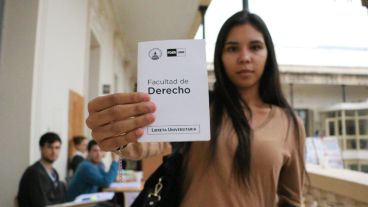 Una estudiante muestra su libreta de la Facultad de Derecho. (Alan Monzón/Rosario3.com)