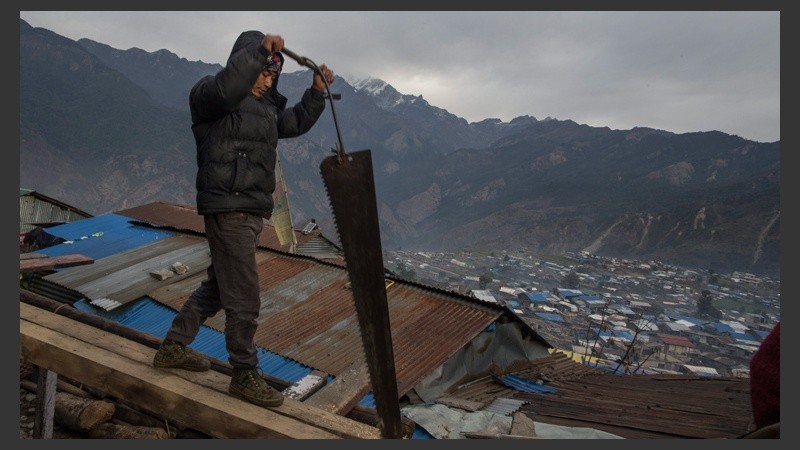 Un hombre trabaja en la reconstrucción de su casa en Barpak, una de las localidades más afectadas por el terremoto del 2015. (EFE)