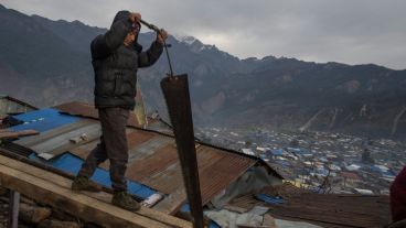 Un hombre trabaja en la reconstrucción de su casa en Barpak, una de las localidades más afectadas por el terremoto del 2015. (EFE)
