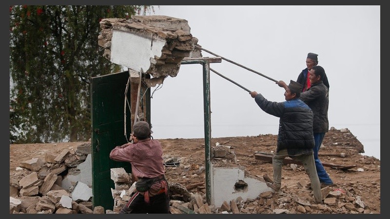 Lugareños terminan de demoler una casa dañada por el terremoto en la localidad de Dhunche. (EFE)