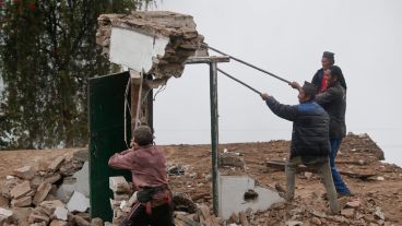 Lugareños terminan de demoler una casa dañada por el terremoto en la localidad de Dhunche. (EFE)