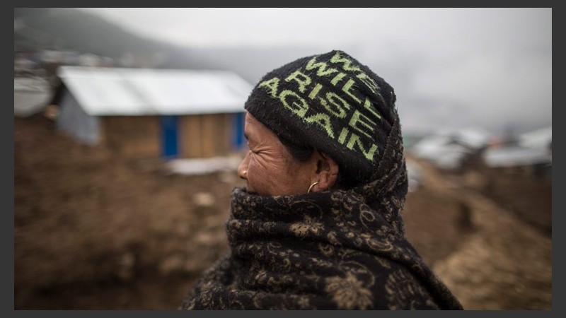 Una anciana lleva un gorro con el lema 