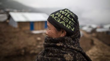 Una anciana lleva un gorro con el lema "Nos levantaremos de nuevo" tras una fuerte nevada en Gupsipakha, Laprak. (EFE)