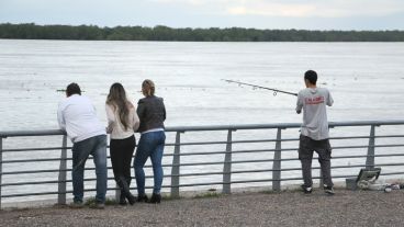 Tres curiosos observan los movimientos de uno de los pescadores. (Alan Monzón/Rosario3.com)