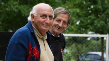 Dos hombres posan la mirada en un jugador durante un lanzamiento. (Alan Monzón/Rosario3.com)