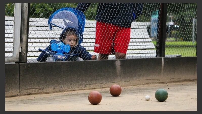 Un niño observa con curiosidad las bochas en pleno partido. (Alan Monzón/Rosario3.com)