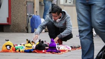 Un joven acomoda unos gorros que pondrá a la venta. (Alan Monzón/Rosario3.com)