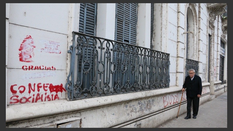 Un hombre camina por delante de uno de los clásicos balcones de siglo pasado que aún persisten por calle Corrientes. (Rosario3.com)