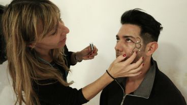 Un mujer maquilla a uno de los atletas. (Alan Monzón/Rosario3.com)