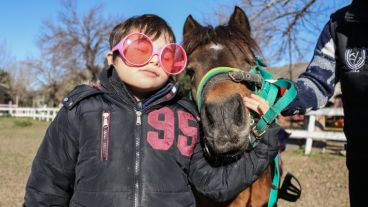 Un pequeño posa para la foto junto a su caballo. La interacción entre ambos es la clave del método terapéutico. (Alan Monzón/Rosario3.com)