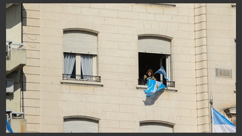 Una señora flamea su bandera asomada desde la ventana de su departamento frente al Monumento. (Alan Monzón/Rosario3.com)