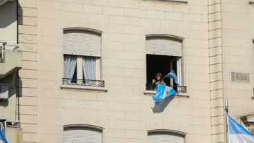 Una señora flamea su bandera asomada desde la ventana de su departamento frente al Monumento. (Alan Monzón/Rosario3.com)