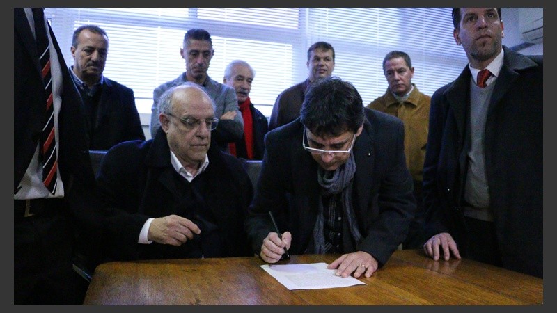 Bermúdez firmando el acta de traspaso junto a Riccobelli. 