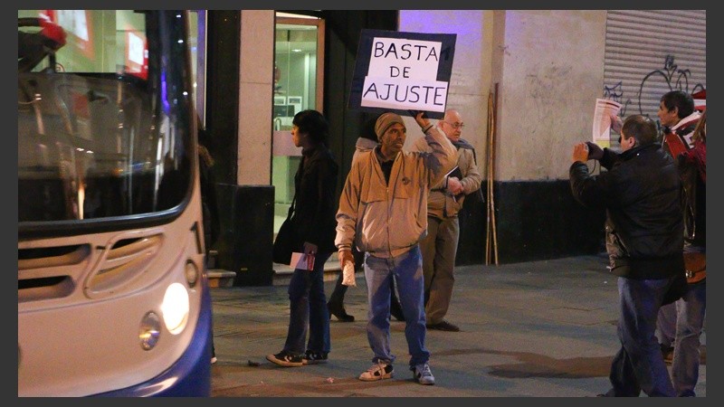 Un hombre muestra un cartel en plena peatonal Córdoba.