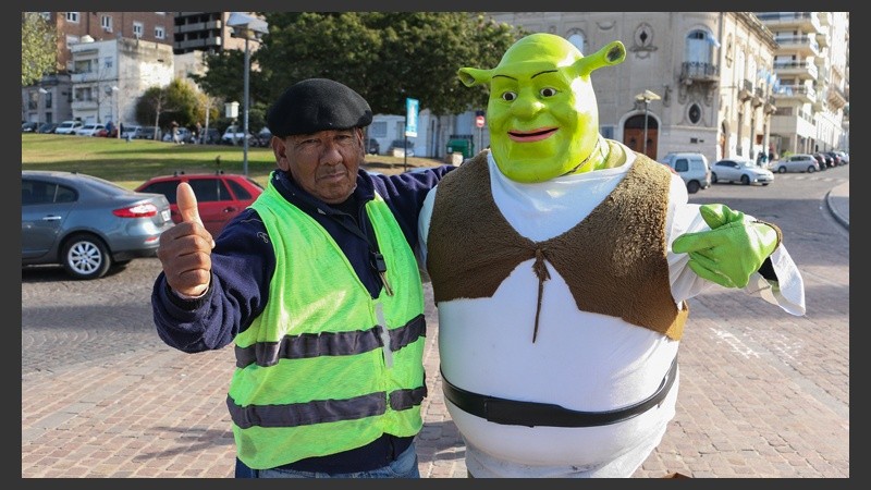 Un cuidacoche del lugar, que a veces le da una mano a Shrek,  posa junto a él para la cámara. (Alan Monzón/Rosario3.com) 