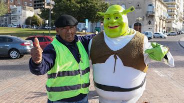 Un cuidacoche del lugar, que a veces le da una mano a Shrek,  posa junto a él para la cámara. (Alan Monzón/Rosario3.com)