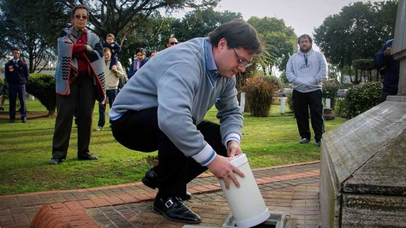 El presidente comunal de Zavalla depositando la nueva cápsula en la plaza. 