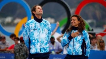 Cecilia al momento de recibir el oro olímpico, junto a su compañero Santiago Lange.