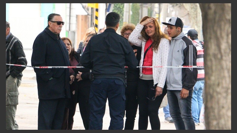 La hija de la víctima junto a vecinos, todos conmovidos por el crimen.