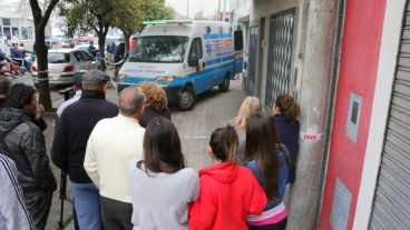Una ambulancia del SIES para retirar el cuerpo mientras vecinos observan.