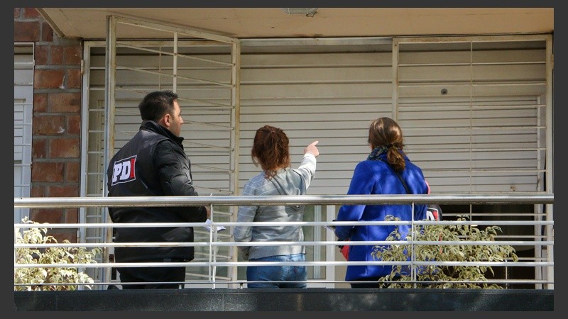 Una mujer señala la marca de uno de los impactos en el edificio lindero al del Tiki Martínez. 