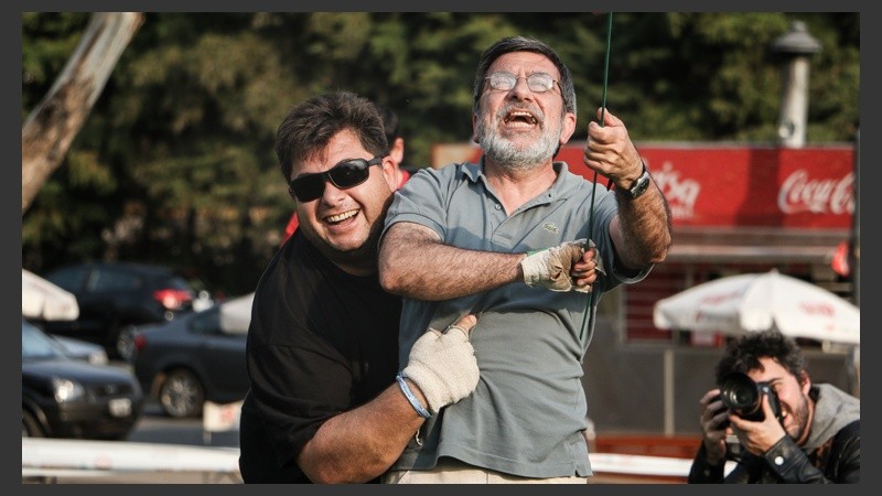 Dos hombres bromean tras remontar uno de los barriletes gigantes que fueron exhibidos. (Alan Monzón/Rosario3.com)