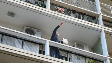 Un señor arroja desde su balcón flores durante el paso de la Virgen. (Alan Monzón/Rosario3.com)