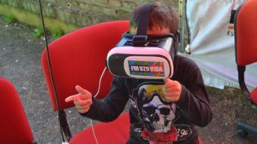 Un nene simula disparar con su mano mientras disfruta el juego de realidad virtual.