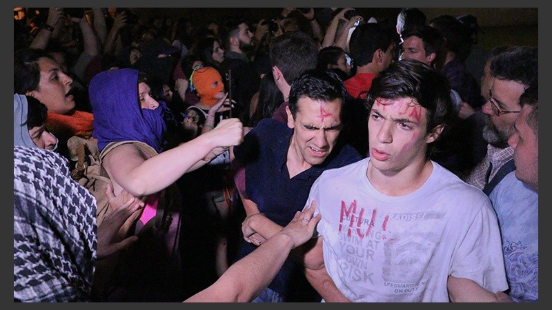 Unos jóvenes rezando frente a la Catedral esperando el paso de la marcha. Fueron agredidos.