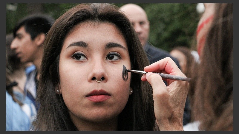 Una chica se pinta antes de iniciar la marcha. (Alan Monzón/Rosario3.com)