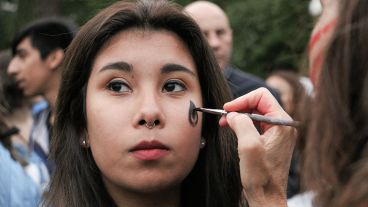 Una chica se pinta antes de iniciar la marcha. (Alan Monzón/Rosario3.com)