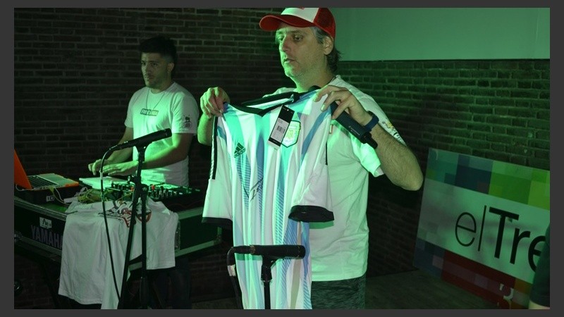 El conductor Sebastián Oneto le muestra al público la camiseta de Messi. 