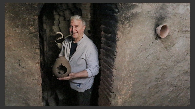 El alfarero saca un cacharro de uno de los hornos históricos. 