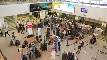 Cientos de pasajeros en espera dentro del aeropuerto.