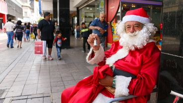 Un Papá Noel toma un descanso en peatonal San Martín. (Rosario3.com)