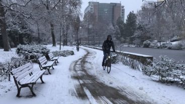 Un ciclista circula por un parque cubierto de nieve en Frakfurt, Alemania)
