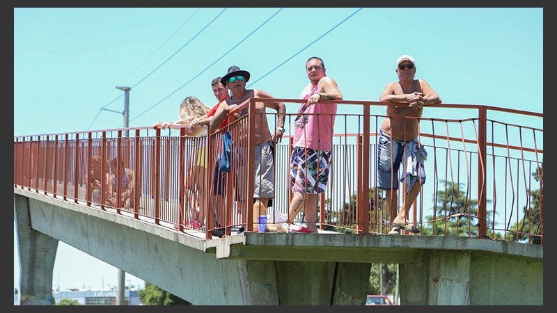 Sobre el puente esperando el paso de los vehículos en un mediodía caluroso en la ciudad.