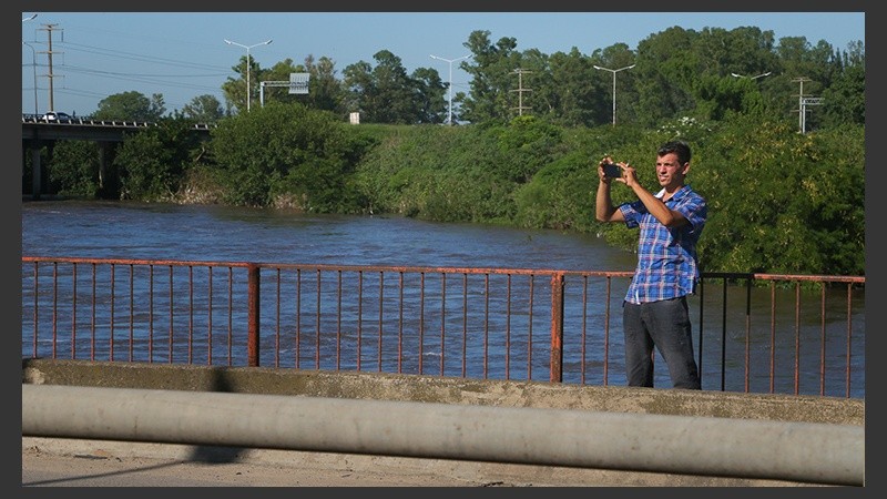 El arroyo muy crecido. Los curiosos pasan y sacan fotos.