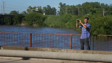 El arroyo muy crecido. Los curiosos pasan y sacan fotos.