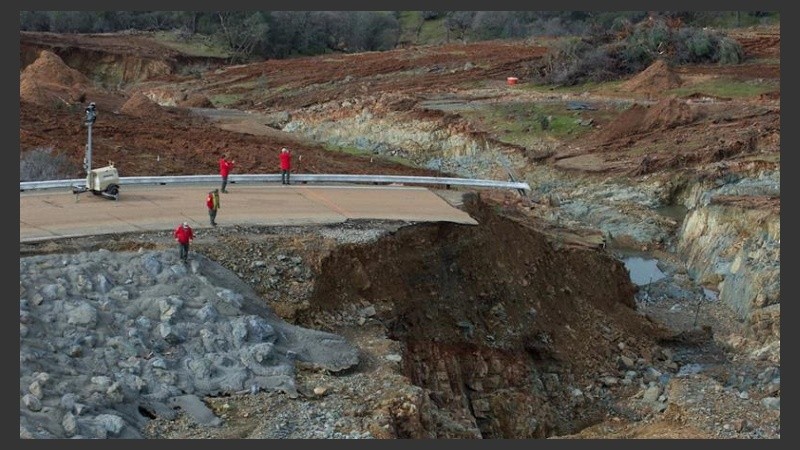 Trabajadores inspeccionan daños bajo el aliviadero auxiliar de la presa.