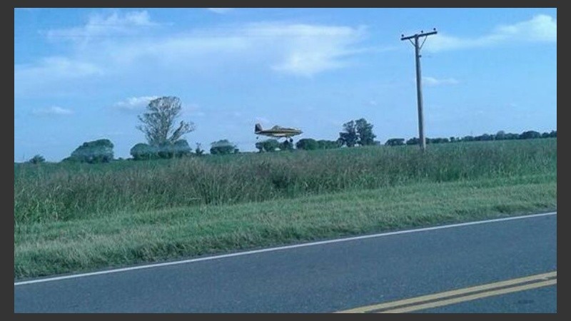 La avioneta en plena acción, sobre la ruta provincial 13.