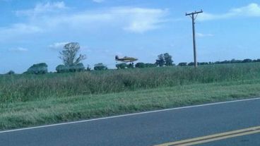 La avioneta en plena acción, sobre la ruta provincial 13.