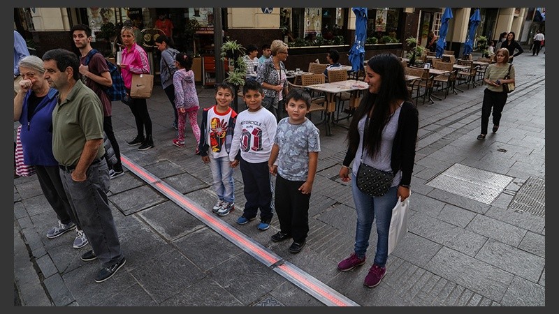 Unos niños en peatonal Córdoba a la espera del semáforo en verde.